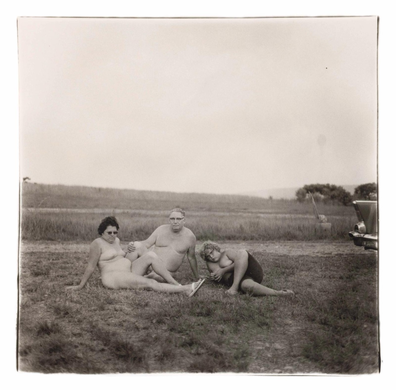 En familie fotograferet en aften i en nudistlejr